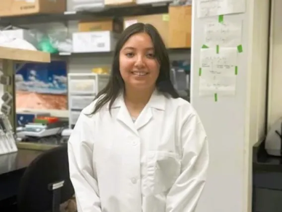 Picture of Leila standing in front of her lab bench