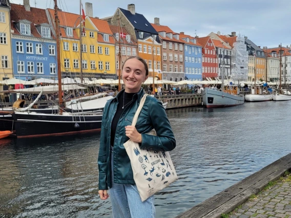 Picture of Erin Schuette standing in front of colorful houses along a canal in Copenhagen, Denmark