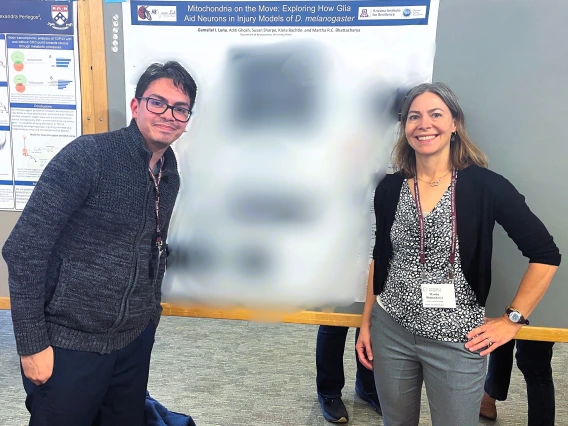 Gamaliel Isai Luna and Martha Bhattacharya standing next to scientific poster