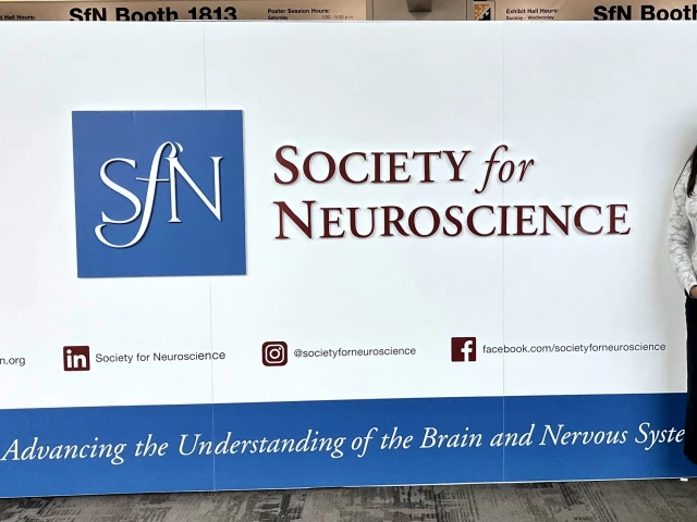 Ava Pal poses in front of the Society for Neuroscience sign