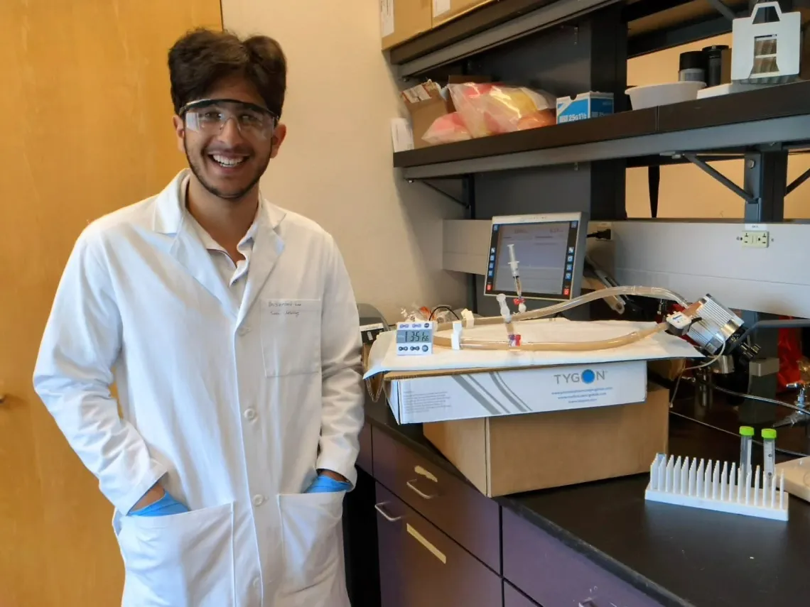 Picture of Sami Muslmani standing in front of his laboratory bench