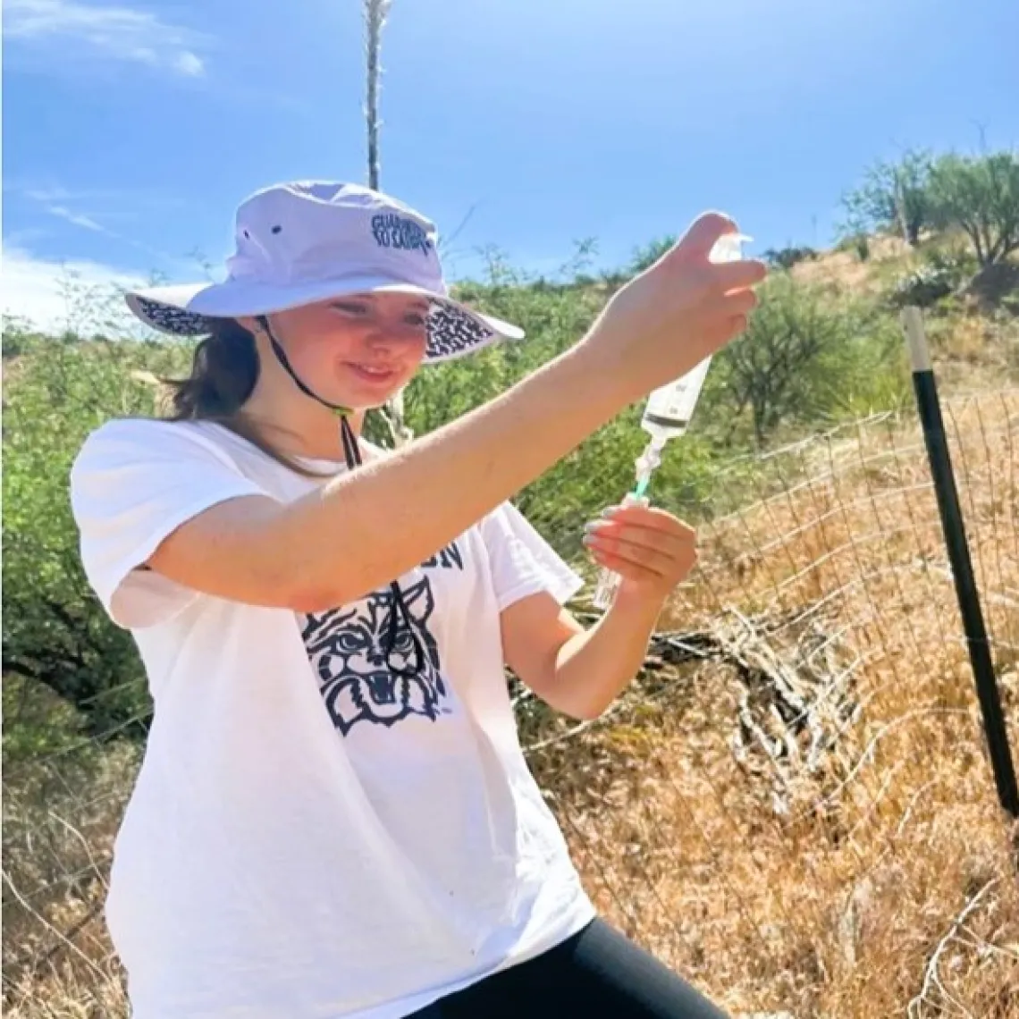 Picture of Jordan in a field, pouring water into a vial