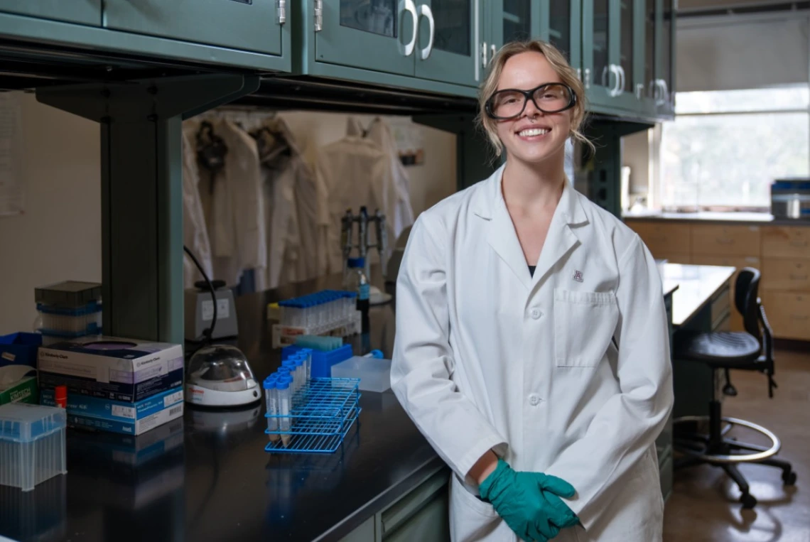 Picture of Paige Wagstaff standing in front of a laboratory bench