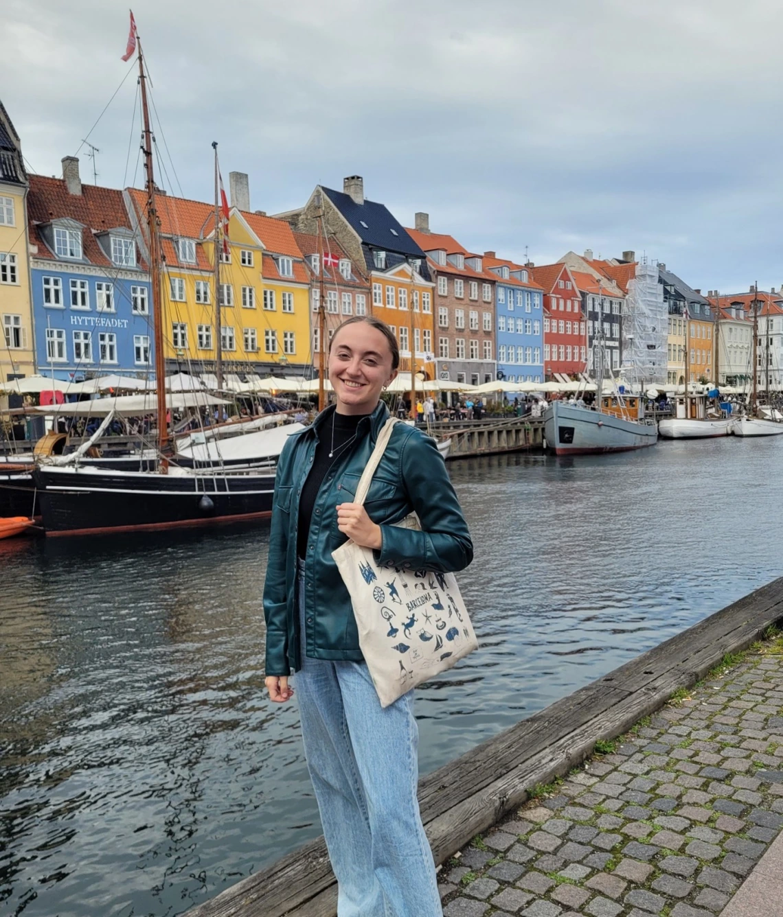 Picture of Erin Schuette standing in front of colorful houses along a canal in Copenhagen, Denmark