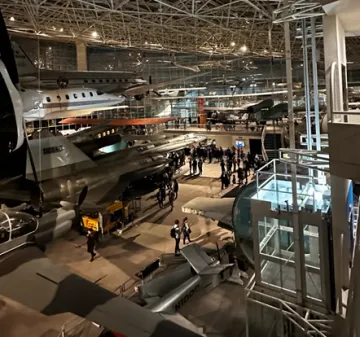 Picture of historic airplanes hanging from the ceiling in a museum