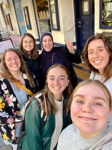 Group picture of Erin Schuette and her labmates in front of a restaurant in Denmark