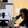 Picture of Truc Le looking through a microscope